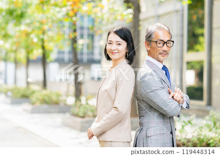 Smiling business people standing together in an office district 119448314