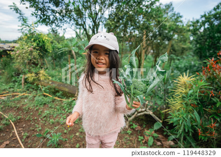 A Joyful Child Engaging in Playtime Outdoors Within a Beautiful Lush Green Garden 119448329