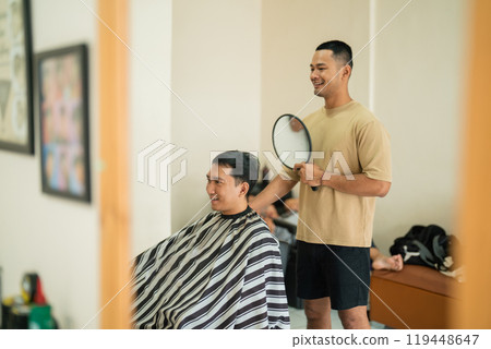 A man is currently getting his hair cut by a barber in a room 119448647