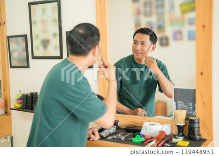 A man is thoroughly brushing his teeth while standing in front of a mirror 119448931