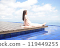 A senior woman with long hair sitting on the wooden deck of Biwako Terrace 119449255