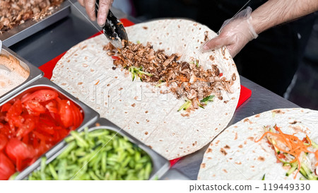 Mouthwatering shawarma wrap preparation with fresh ingredients 119449330