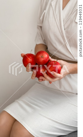 Woman holding fresh red apples in minimalist white dress Woman holding fresh red apples in minimalist white dress 119449331