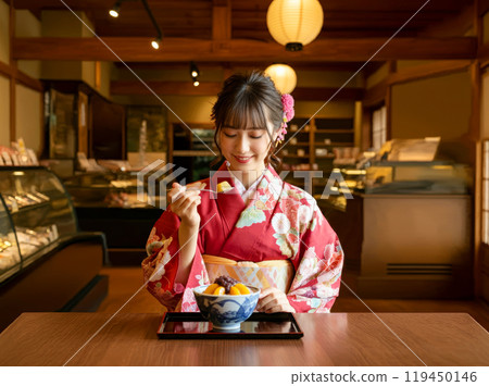 Japanese woman in kimono eating anmitsu at a sweet shop 1 119450146