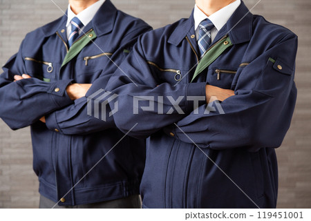 A middle-aged male businessman in work clothes with his arms folded 119451001