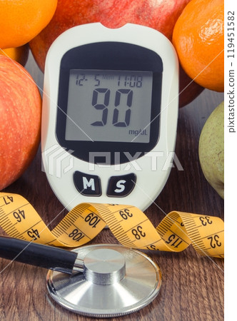 Glucometer with sugar level, fresh fruits, stethoscope and tape measure 119451582