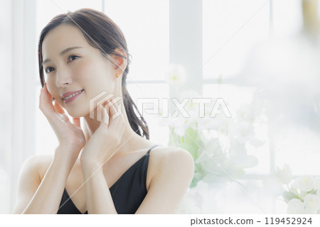 窗邊穿著黑色吊帶背心洋裝的女人 119452924