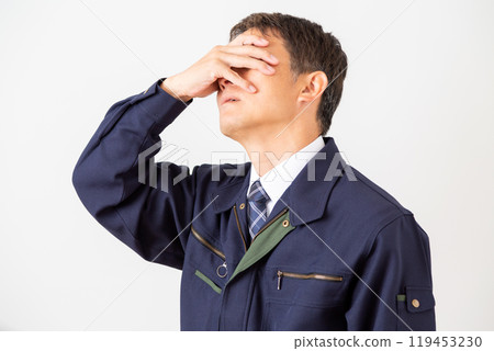 A middle-aged male businessman in work clothes who is worried A middle-aged male businessman in work clothes who is worried 119453230