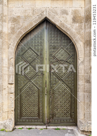Ornate double doors in Baku Old City, Azerbaijan showcase intricate carvings, reflecting architectural beauty Ornate double doors in Baku Old City, Azerbaijan showcase intricate carvings, reflecting architectural beauty 119453231
