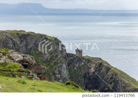 View of rugged cliffs meeting ocean and sky near Slieve League with an old stone structure View of rugged cliffs meeting ocean and sky near Slieve League with an old stone structure 119453766