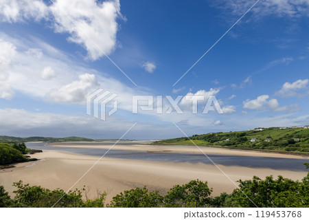 The Gweebarra River at low tide flows into the Atlantic revealing endless sandy shores, blue skies The Gweebarra River at low tide flows into the Atlantic revealing endless sandy shores, blue skies 119453768