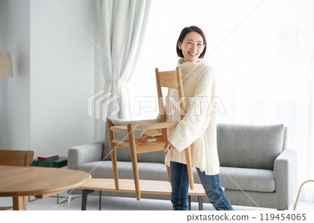 Woman moving furniture chair 119454065
