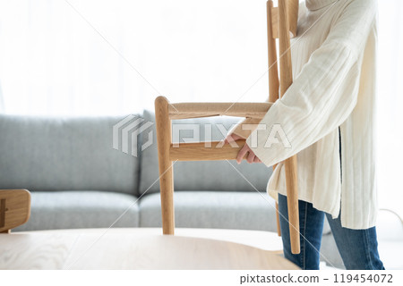 女人搬家具，手裡拿著椅子 119454072