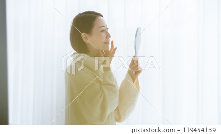 Woman looking in the mirror 119454139