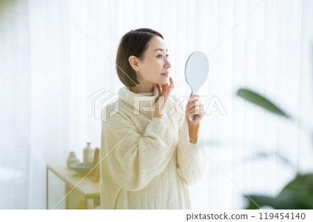 Woman looking in the mirror Woman looking in the mirror 119454140