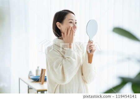 Woman looking in the mirror 119454141