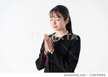 身穿喪服、雙手合十的年輕女子 119454469