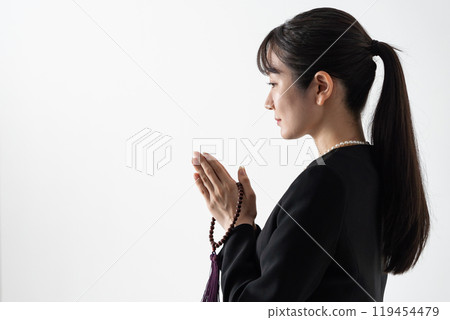 身穿喪服、雙手合十的年輕女子 119454479