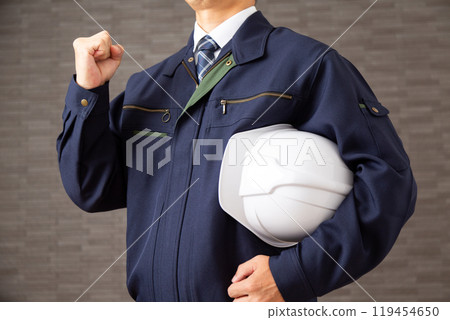 一位穿著工作服的中年商人握緊拳頭打拳。 一位穿著工作服的中年商人握緊拳頭打拳。 119454650