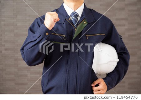 A middle-aged male businessman in work clothes making a fist-pumping gesture 119454776