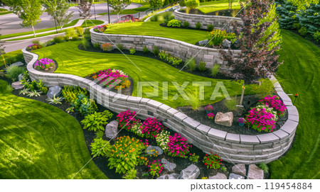 Landscaped home garden with terraces, rocks and stone retaining walls, beautiful design of luxury house backyard in summer. Concept of landscaping, back yard, flower, nature 119454884