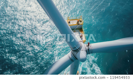 Wind turbine in sea, engineers work at top of windmill in ocean, aerial view of people on industrial construction. Theme of energy, industry, power, maintenance 119454933