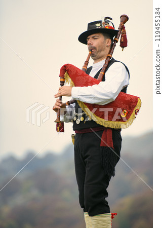 Musician plays bagpipes in the mountains 119455184