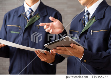 穿著工作服在平板電腦上工作的中年男性商人 119455236