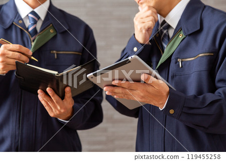 A middle-aged male businessman in work clothes working on a tablet 119455258