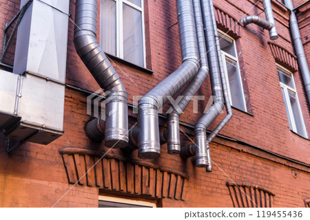 industrial architectural background, pipelines on the facade of vintage factory building 119455436