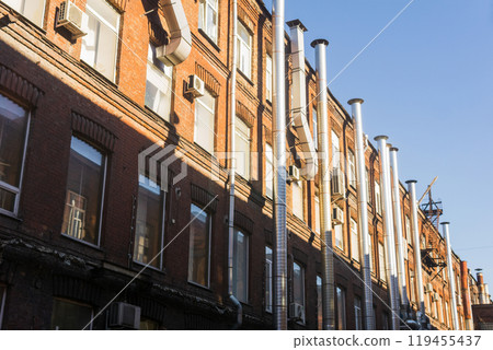 industrial architectural background, pipelines on the facade of vintage factory building 119455437