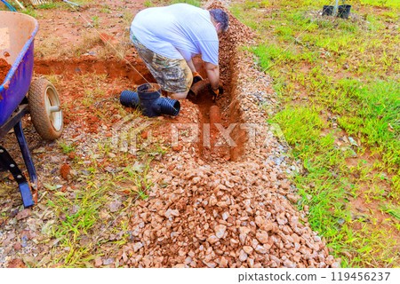 Underground storm sewers are replaced in trench with groundwater system after damage to storm drain systems 119456237