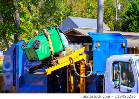 Garbage is removed by municipal cleaning service by loading mixed domestic waste onto garbage trucks 119456256