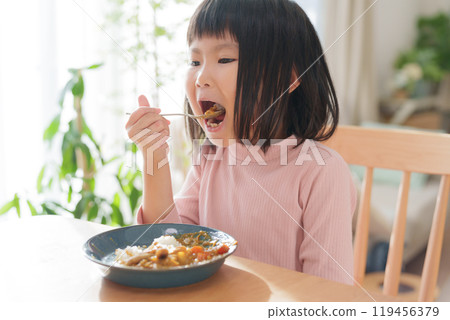 Child eating curry rice 119456379