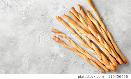 Italian grissini or salted breadsticks on a light stone background 119456436