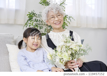 Grandmother and grandchild holding a bouquet in the living room Grandmother and grandchild holding a bouquet in the living room 119457152