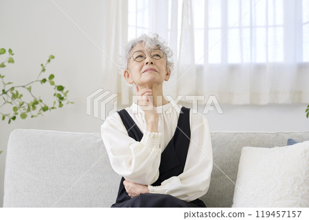 Worried senior woman living room 119457157