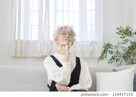 Worried senior woman living room 119457158