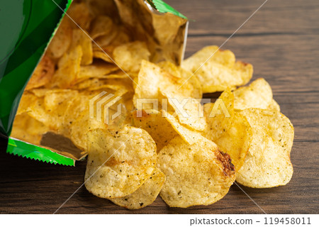 Potato chips, delicious spicy for crips, thin slice deep fried snack fast food in open bag. Potato chips, delicious spicy for crips, thin slice deep fried snack fast food in open bag. 119458011