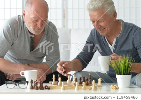 two old senior men playing chess at home 119459466