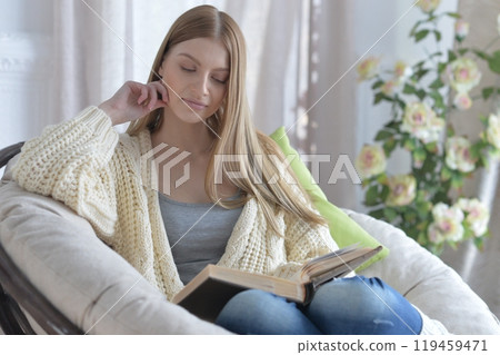 Portrait of young woman in pajamas on bed with fluffy plaid 119459471