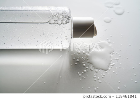 Bottle of facial toner or cleanser on white background with drops of product. Bottle of facial toner or cleanser on white background with drops of product. 119461841
