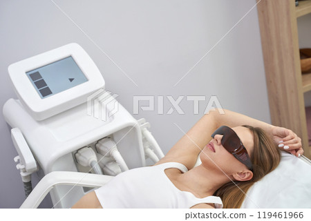 Woman undergoing laser hair removal treatment in modern clinic with protective Woman undergoing laser hair removal treatment in modern clinic with protective 119461966