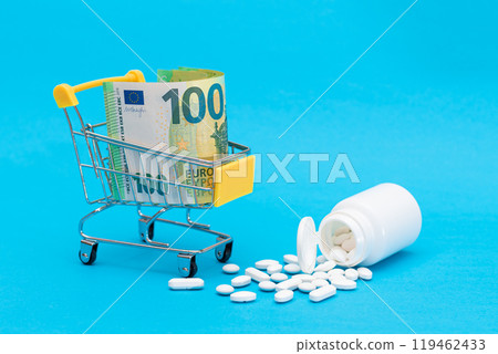 Scattered Pills or Capsules and Shopping Cart on Blue Background Scattered Pills or Capsules and Shopping Cart on Blue Background 119462433