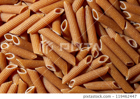 Uncooked Whole Grain Penne Rigate Pasta Background 119462447