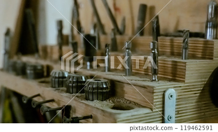 Various tools: file, screwdriver, hammer, pliers, garden tools are displayed on wooden shelf inside rustic garage or manufactory, workshop studio in a rustic garden house. Hobby, leasure activity 119462591