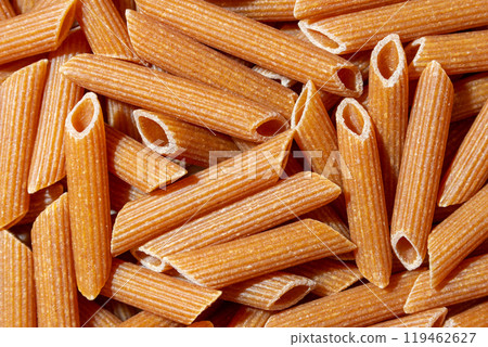 Uncooked Whole Grain Penne Rigate Pasta Background 119462627