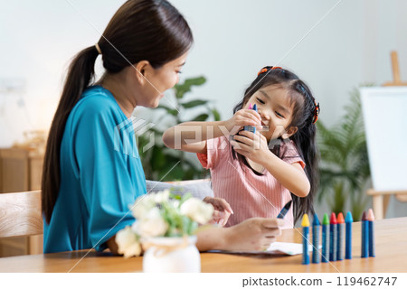 Mother and Daughter Enjoying Creative Time Together at Home with Colorful Crayons and Art Supplies 119462747