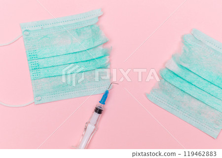 Broken Medical Syringe and Torn Medical Face Mask on the Pink Background 119462883