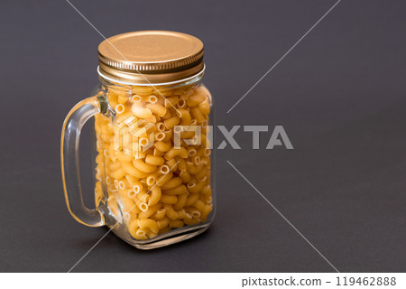 Uncooked Chifferi Rigati Pasta in Glass Jar on Black Background Uncooked Chifferi Rigati Pasta in Glass Jar on Black Background 119462888